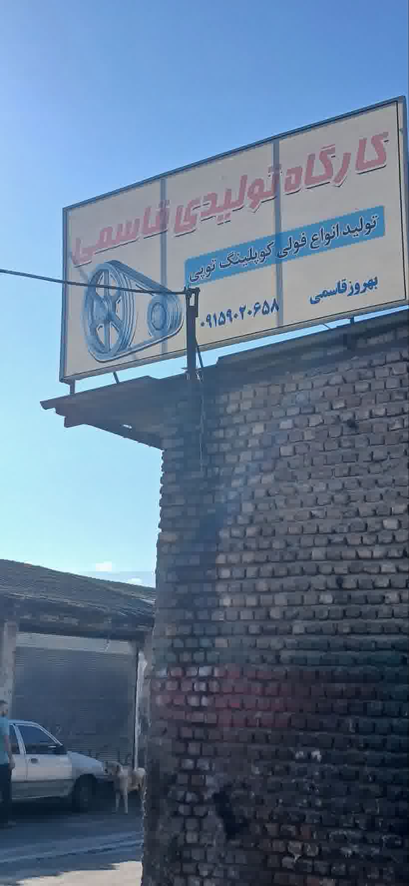 تابلوی سردر مغازه کارگاه قاسمی روی ساختمان آجری